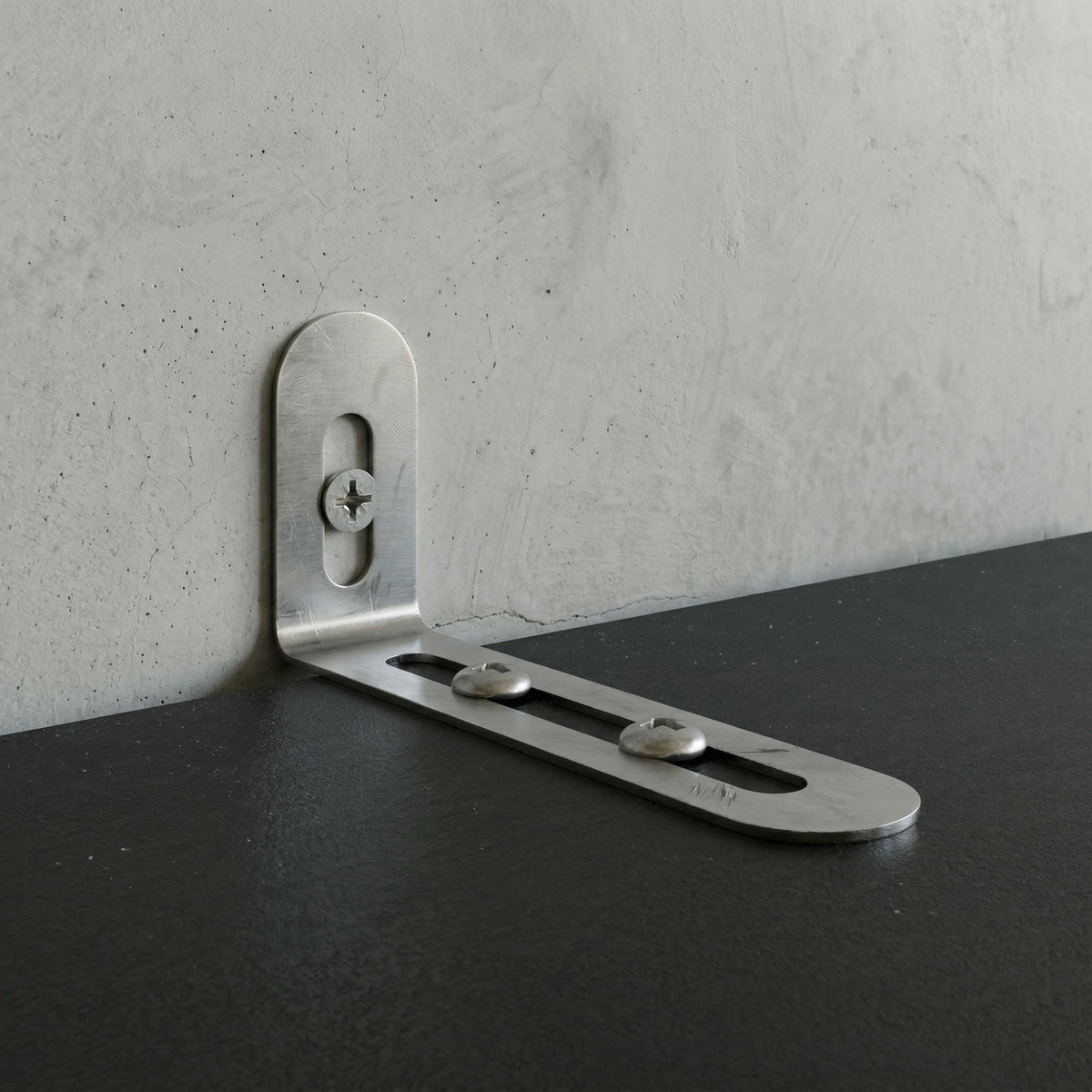 Metal corner bracket on a concrete wall and black surface