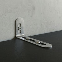 Metal corner bracket on a concrete wall and black surface